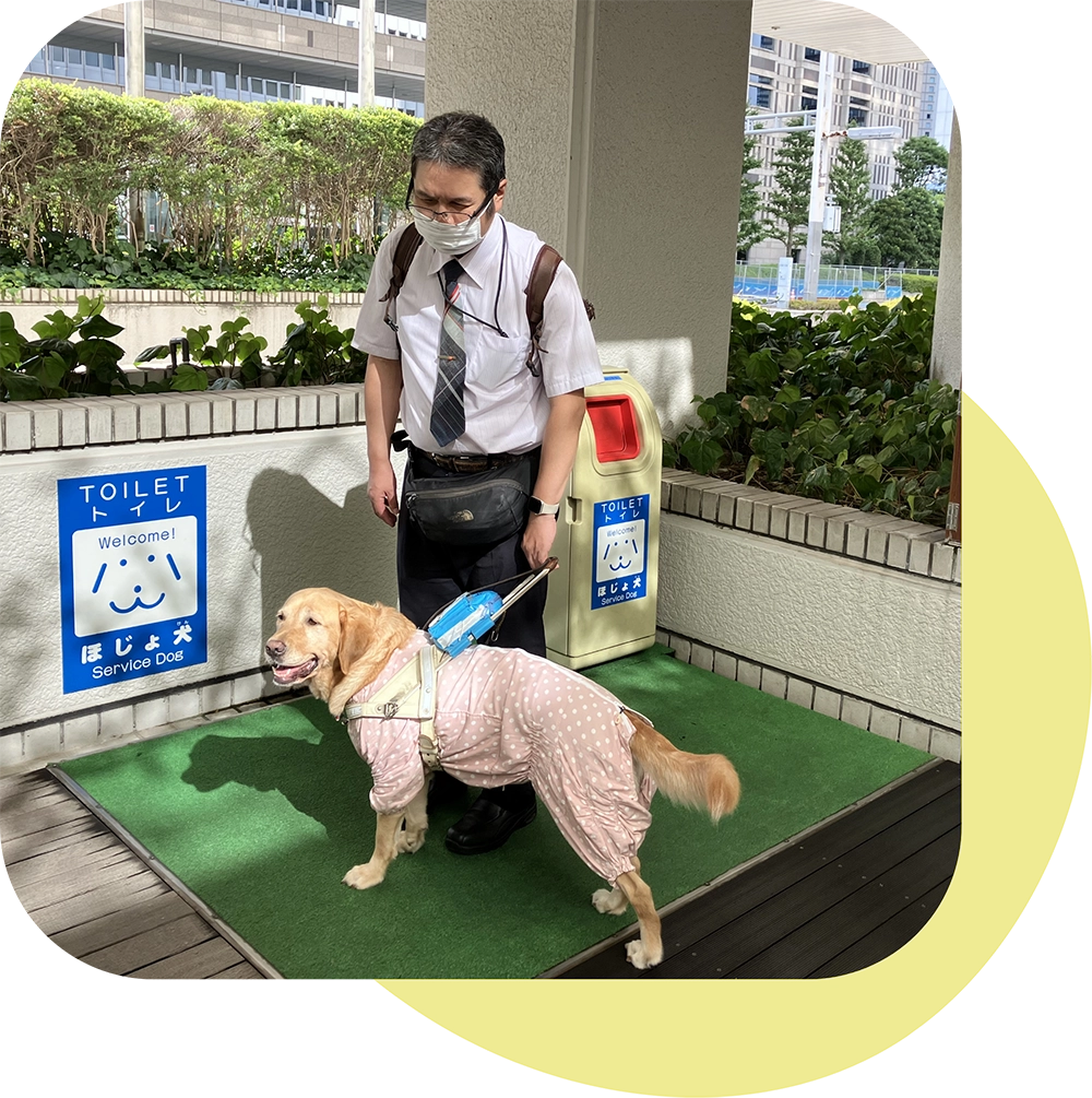 盲導犬用トイレの説明をする松井さん