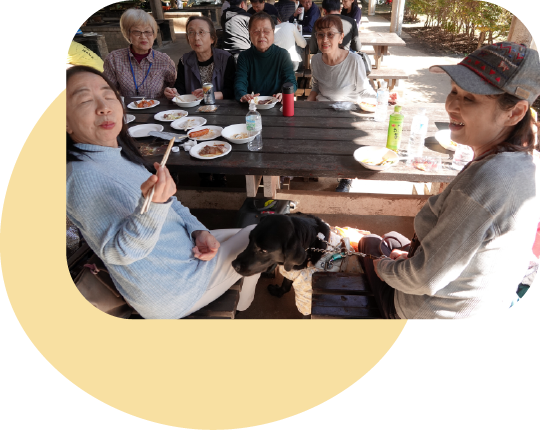 補助犬使用者と一緒にバーベキューを楽しむ参加者たち