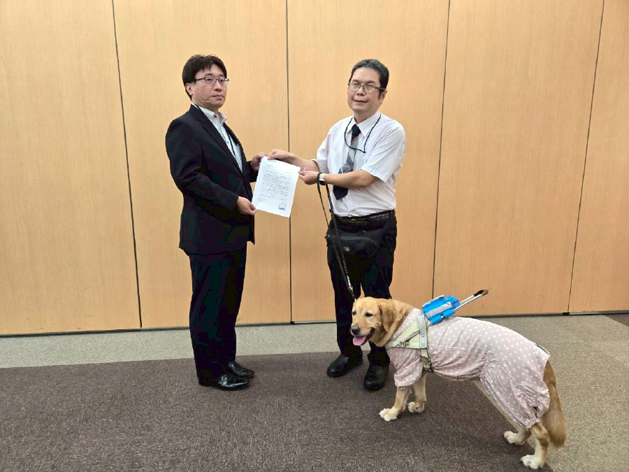 書類を渡す松井さんとウパちゃん