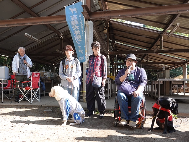 盲導犬体験フェアで盲導犬2匹と盲導犬使用者の講演の様子
