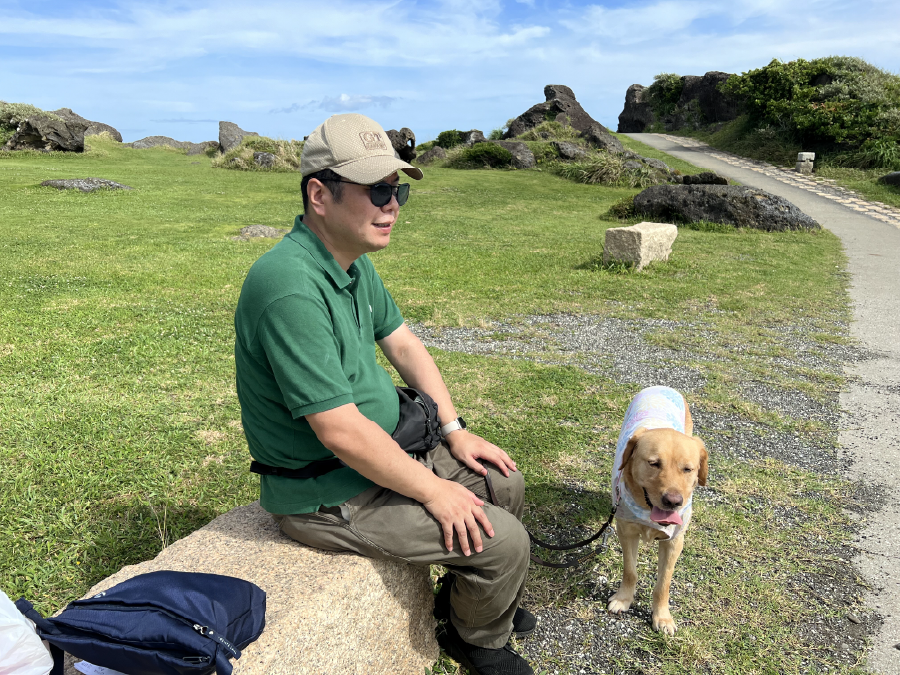 草原のベンチで休憩する松井さんとウパちゃん