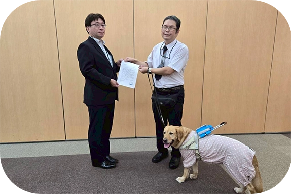 書類を渡す松井さんとウパちゃん